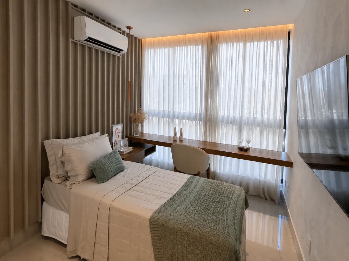 Quarto compacto com cama de solteiro, painel ripado e bancada sob a janela com cortina do piso ao teto